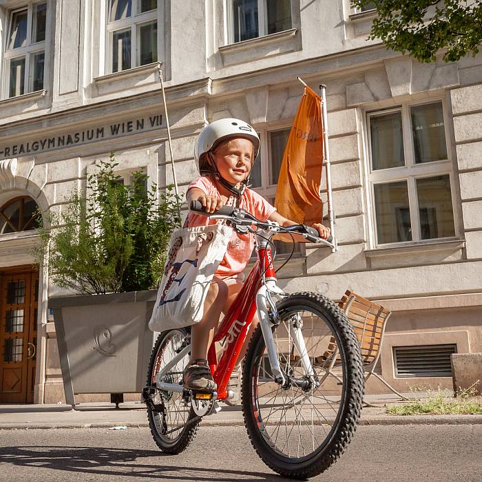 Ein junges Mädchen mit Helm übt das Radfahren im 7. Bezirk.