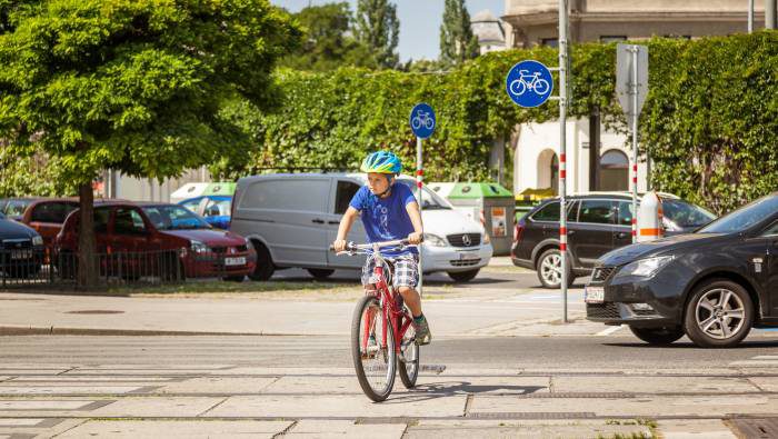 Bub fährt mit dem Fahrrad über eine Kreuzung