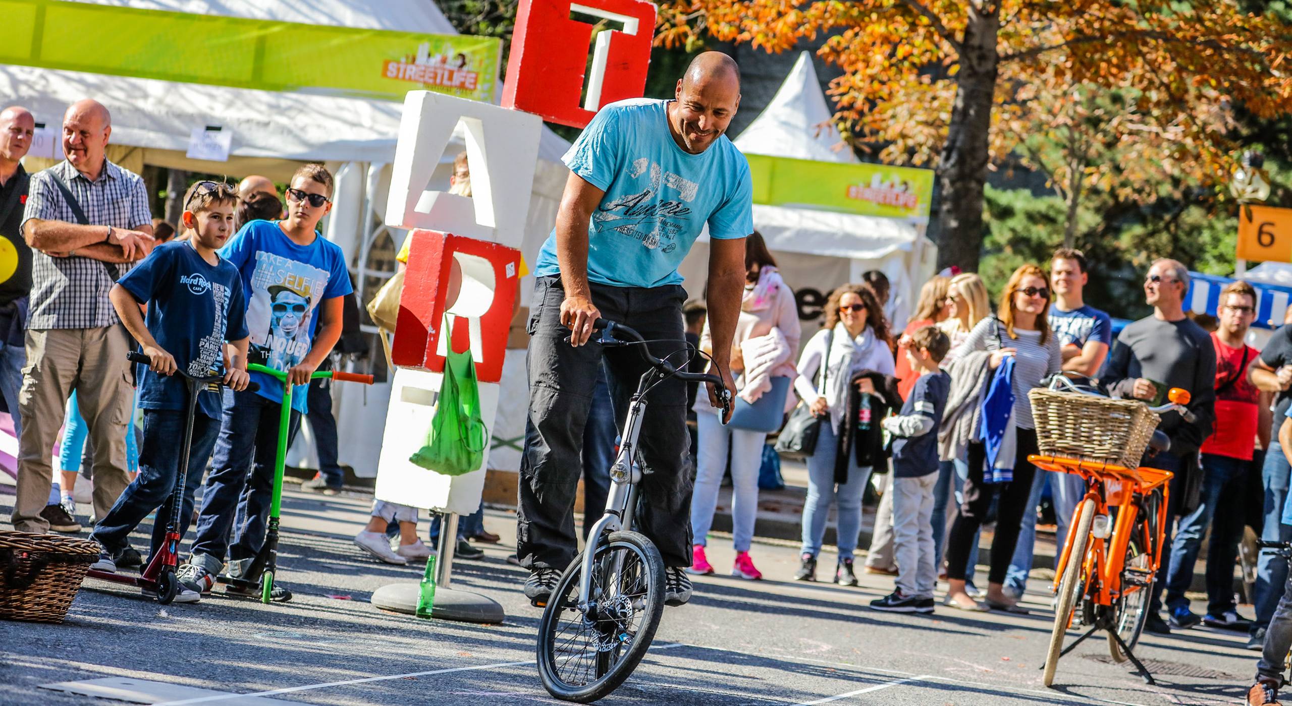 Ein Mann nimmt am Slow Bike Contest beim Streetlife Festival teil. Dabei versucht er so langsam wie möglich auf dem Fahrrad zu fahren ohne das Gleichgewicht zu verlieren.