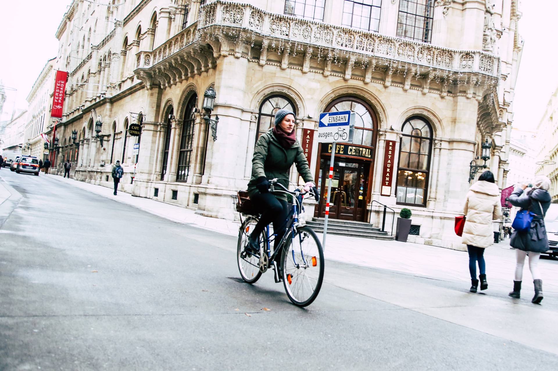 Eine Frau in einer grünen Jacke fährt entlang einer Straße. Neben ihr deutlich erkennbar ein Einbahnschild mit dem Zusatz "ausgenommen Fahrräder". Foto: Christian Fürthner
