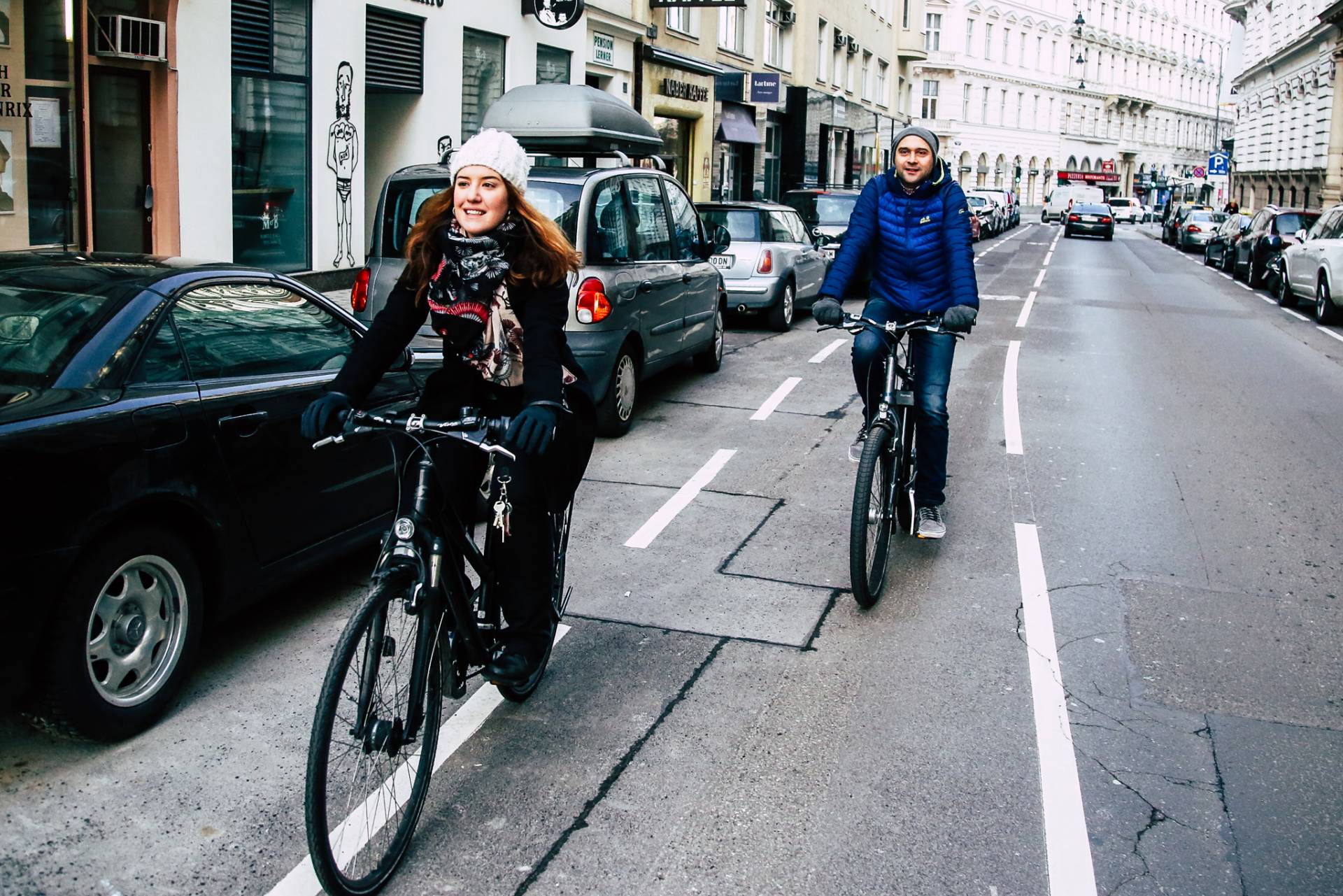 eine Frau mit weißer Mütze und ein Mann mit blauer Jacke fahren hintereinander entlag des Radwegs in der Wipplingerstraße. Foto: Christian Fürthner