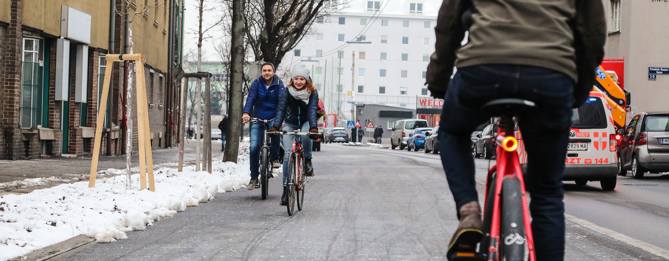 Eine Frau und ein Mann fahren auf dem neuen Radweg entlang der Favoritenstraße, ein Radfahrer kommt ihnen entgegen. Foto aufgenommen von Christian Fürthner