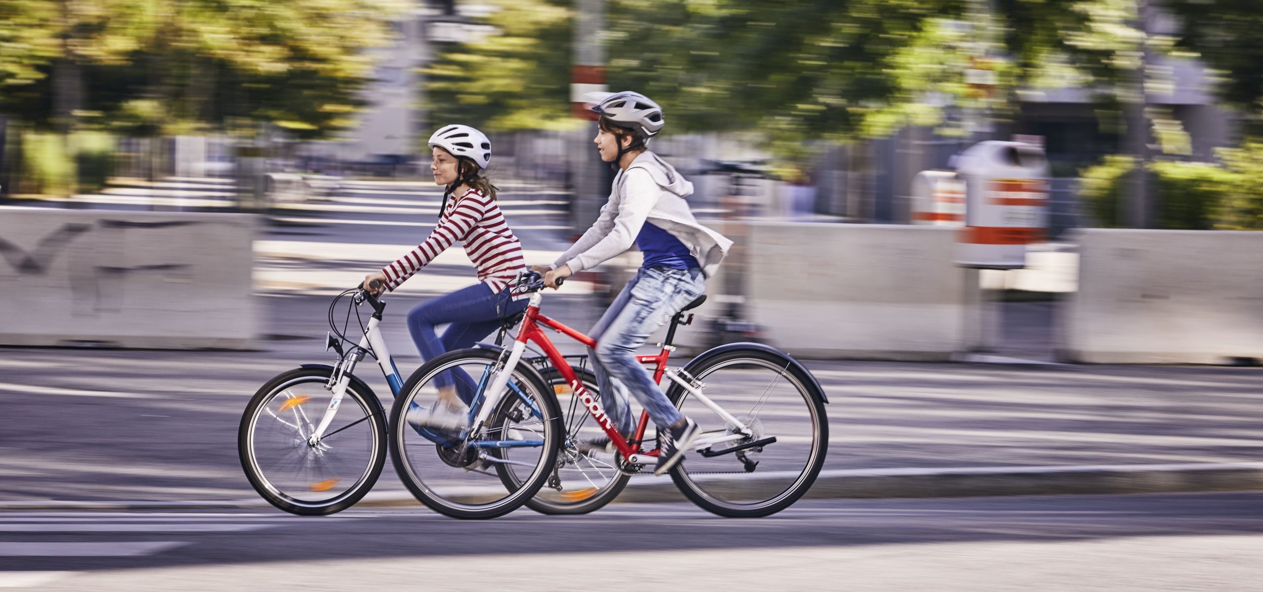 Ein Bub und ein Mädchen fahren mit dem Fahrrad.