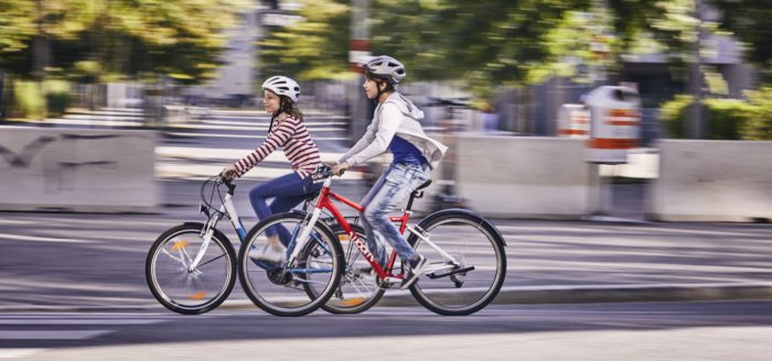 Ein Bub und ein Mädchen fahren mit dem Fahrrad.