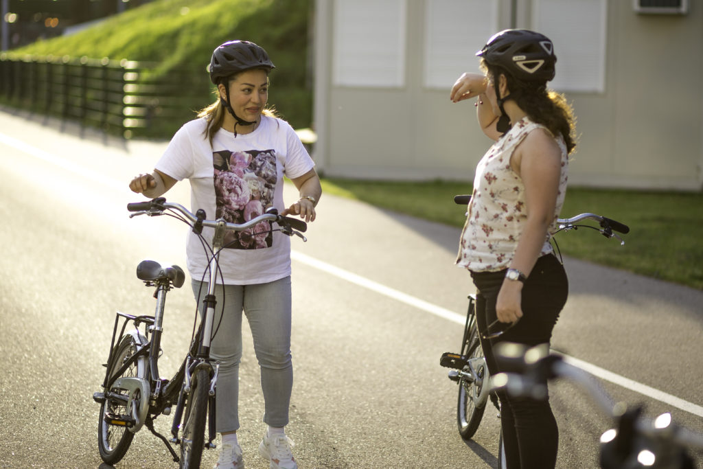 Zwei Frauen mit Fahrrädern stehen sich gegenüber