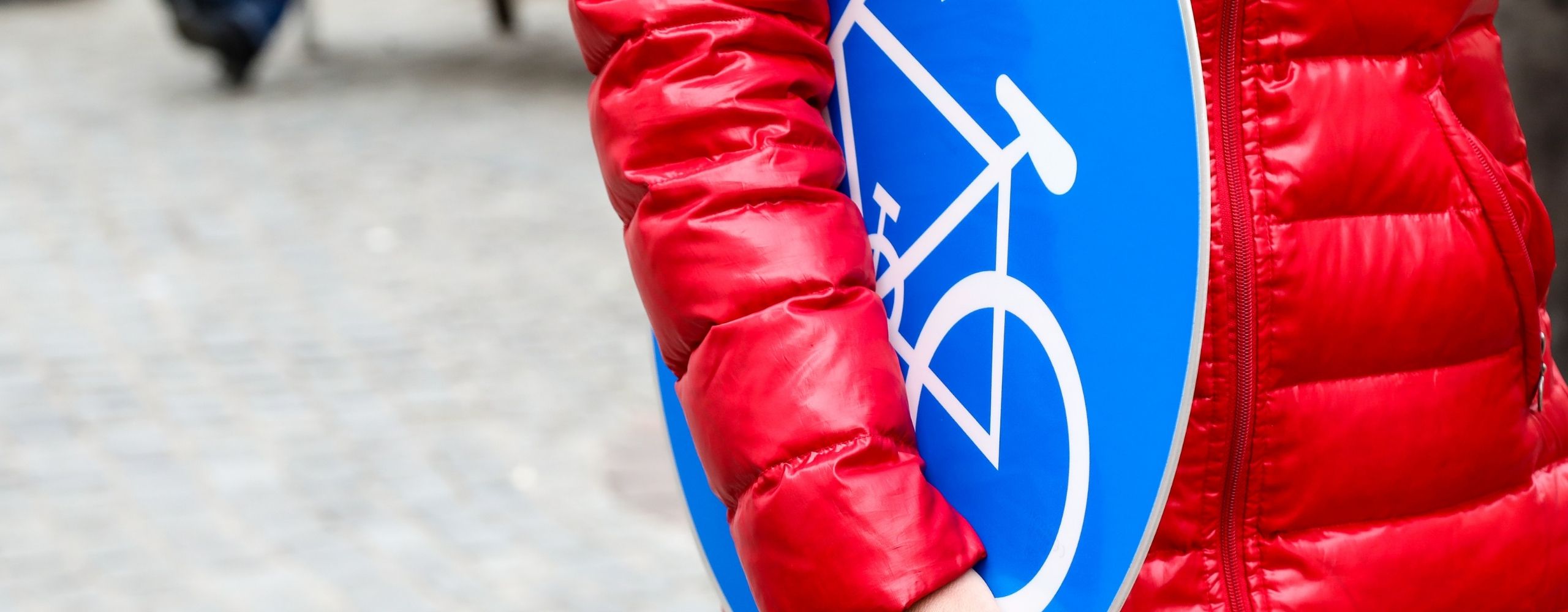 Frau hält Radwegschild, © PID/Christian Fürthner