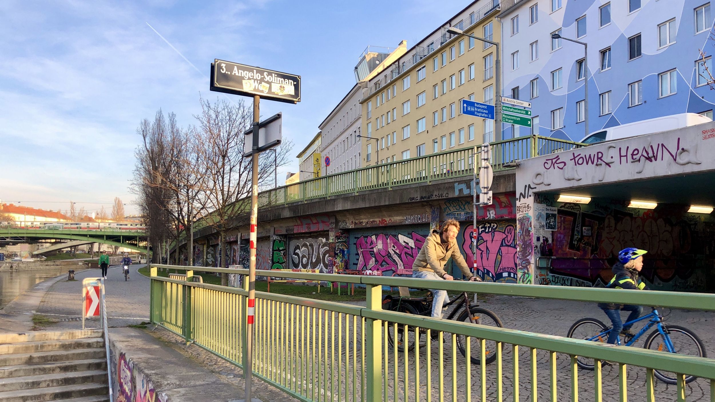 Abzweigung Angelo-Soliman-Weg vom Donaukanal, mit drei Radfahrenden