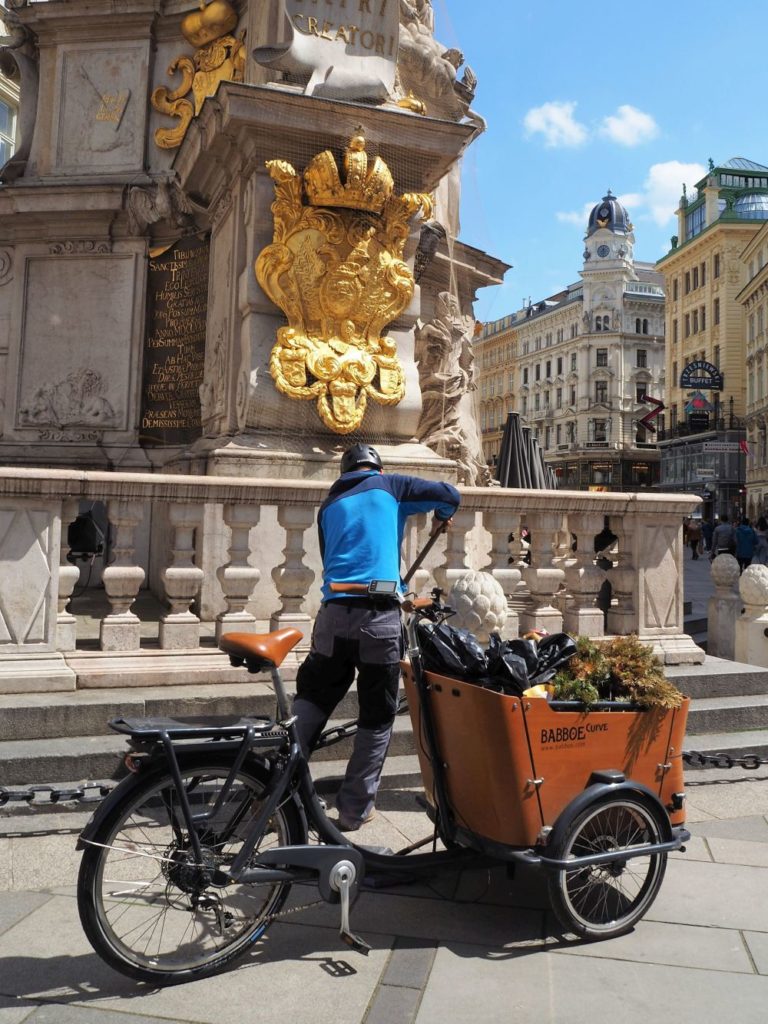 Am Graben, Martin reinigt bei der Pestsäule, das Transportfahrrad steht direkt davor