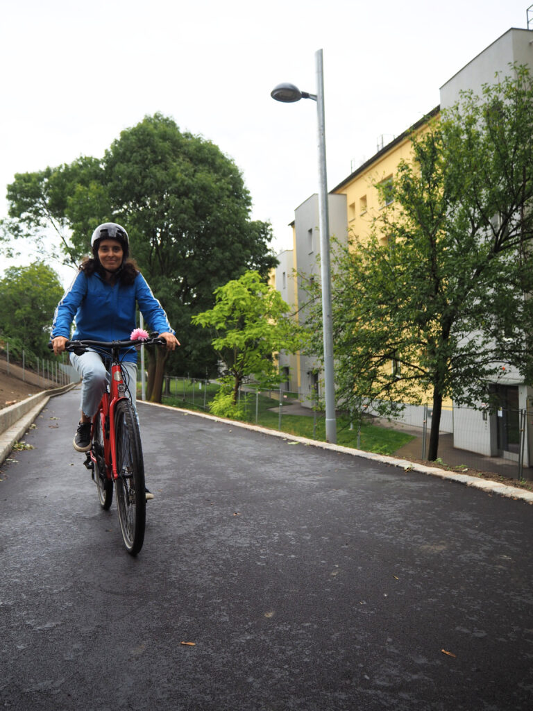 Frau fährt mit Fahrrad einen Radweg entlang