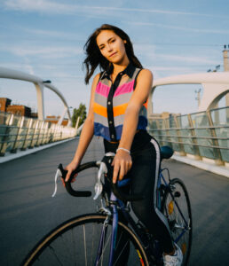 Frau auf Fahrrad trägt eine bunte Design-Sicherheitsweste