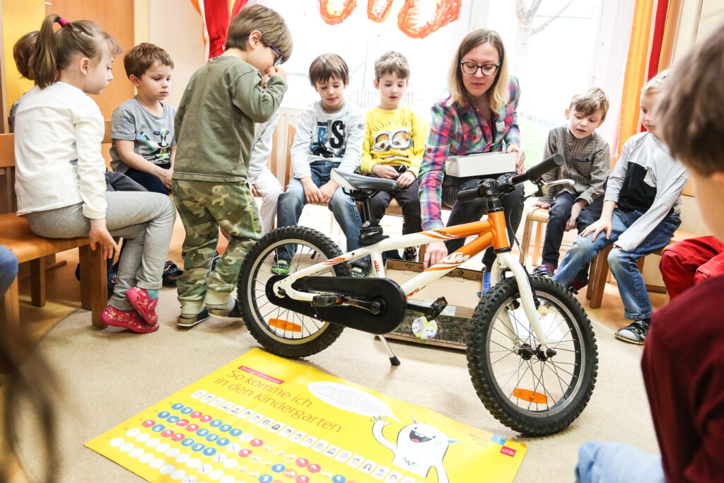 Eine Pädagogin erklärt den Kindern die Bestandteile eines Fahrrads